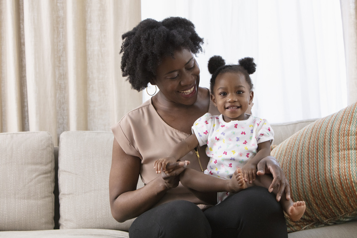 African American mother sitting on the sofa with baby
