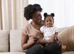 African American mother sitting on the sofa with baby
