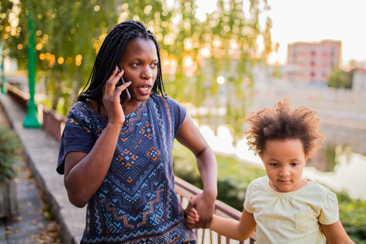 African American woman with child using phone