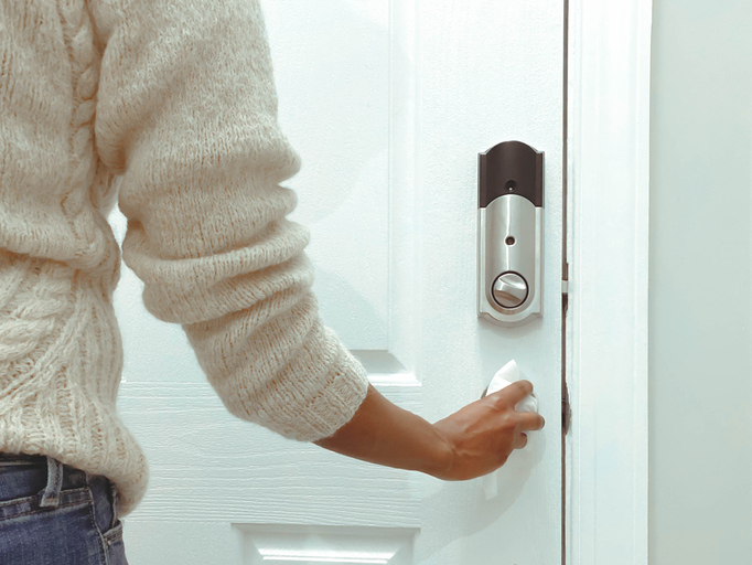 Woman Cleans Doorknob Using Disinfectant Wipe