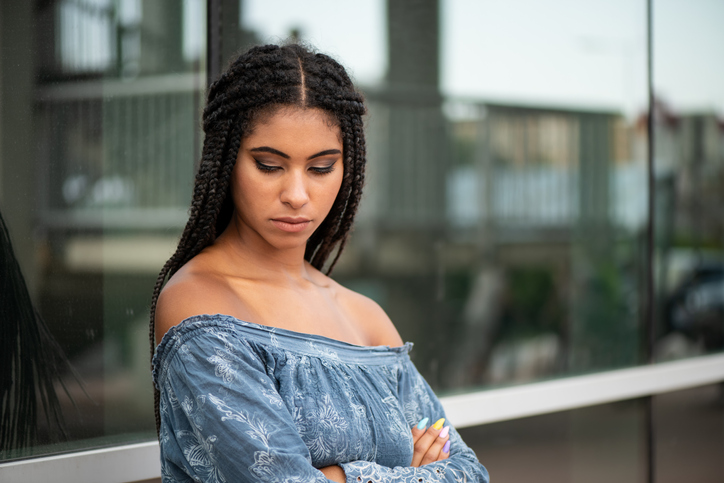 Depressed teen american african woman looking down