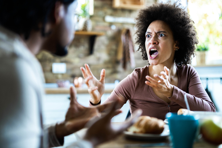 Angry African American couple arguing during breakfast at home.
