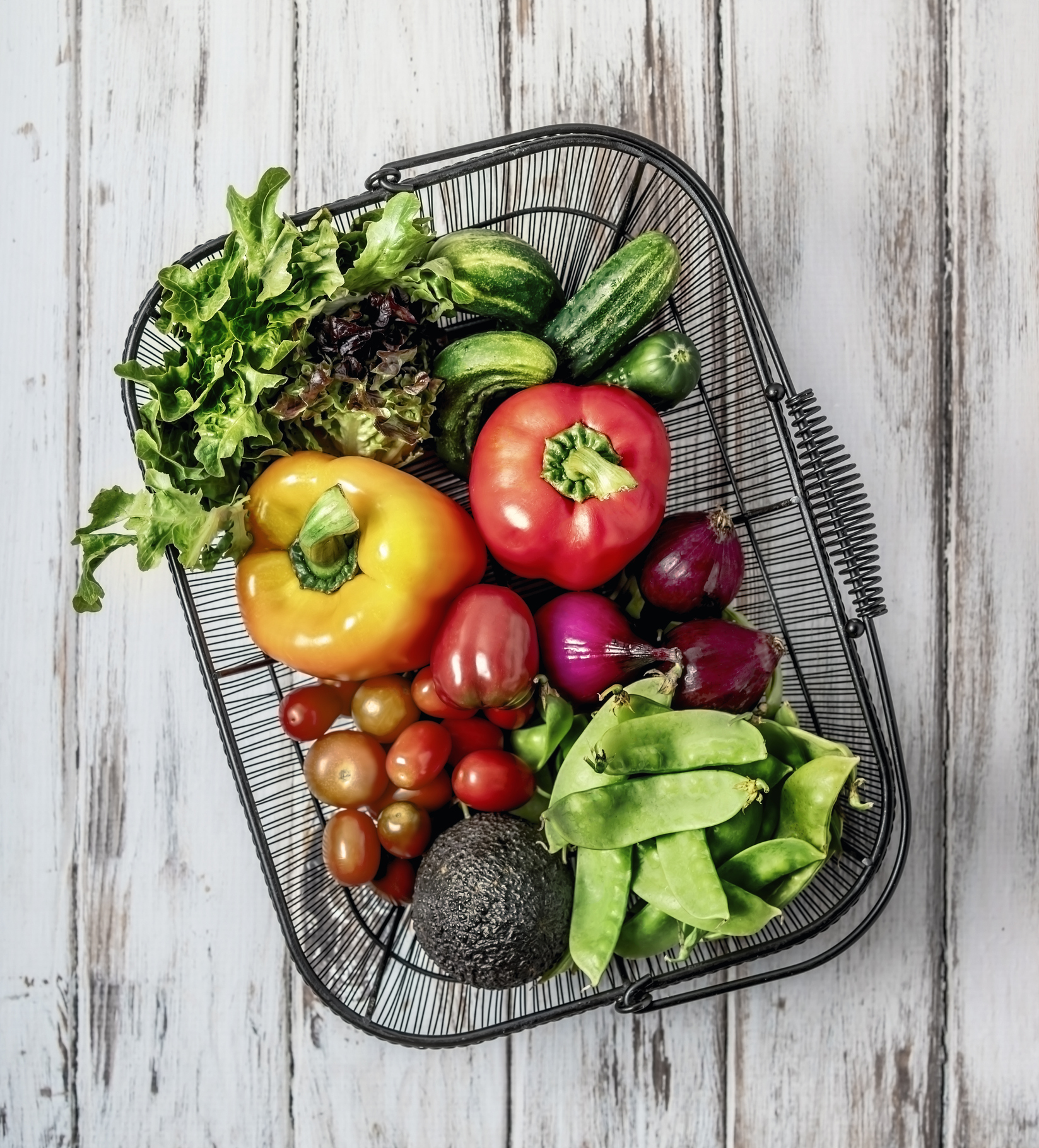 A basket of fresh fruits and vegetables on white background