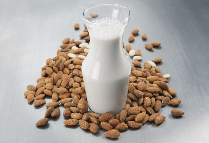 Pitcher of milk and raw almonds