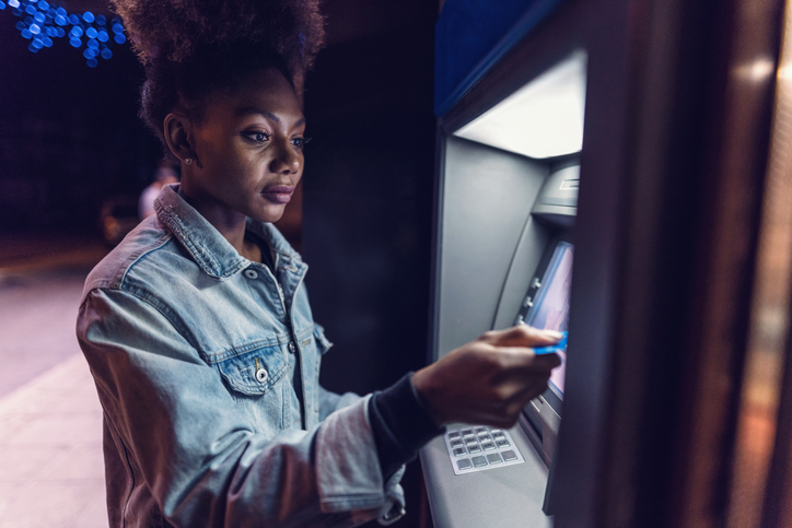 Young woman at the ATM on the street
