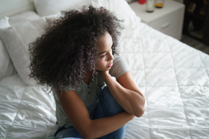 High Angle View Of Woman Sitting On Bed