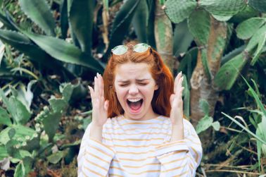 Woman Gesturing While Shouting Against Plants