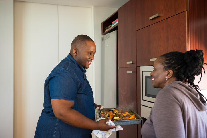 Smiling mother and son talking in kitchen at home