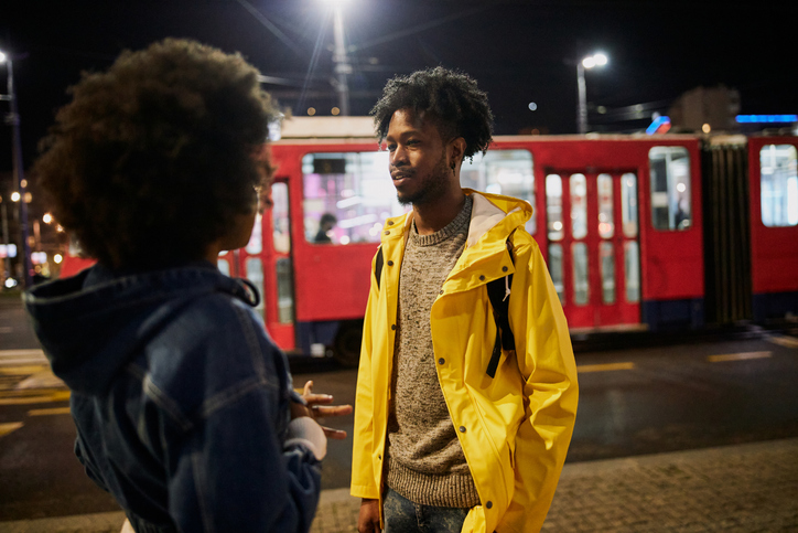 Cheerful young couple in the city at night standing on the street