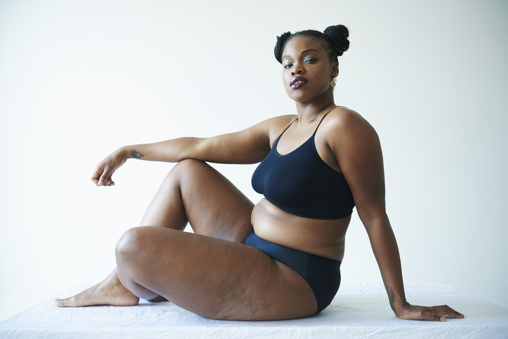 confident curvy woman sitting and looking to camera