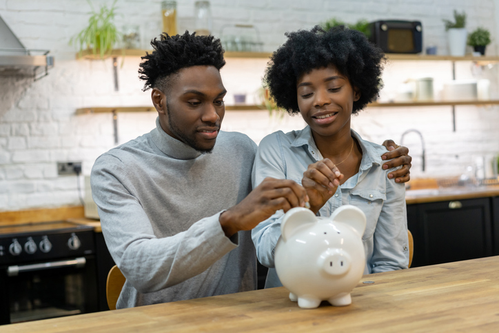 African American couple saving money in a piggybank