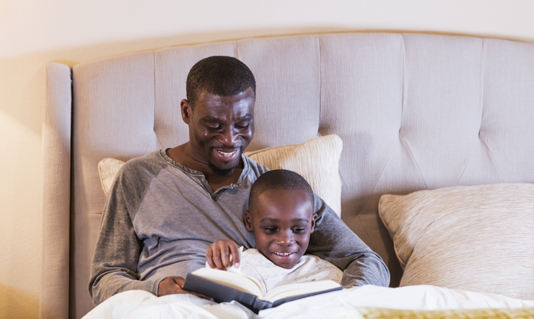 Father reading bedtime story to son