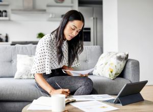 Woman analyzing documents while sitting at home