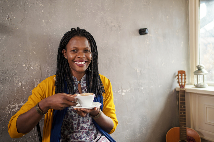 Portrait of beautiful young African American ethnicity woman relaxing with coffee in cafe