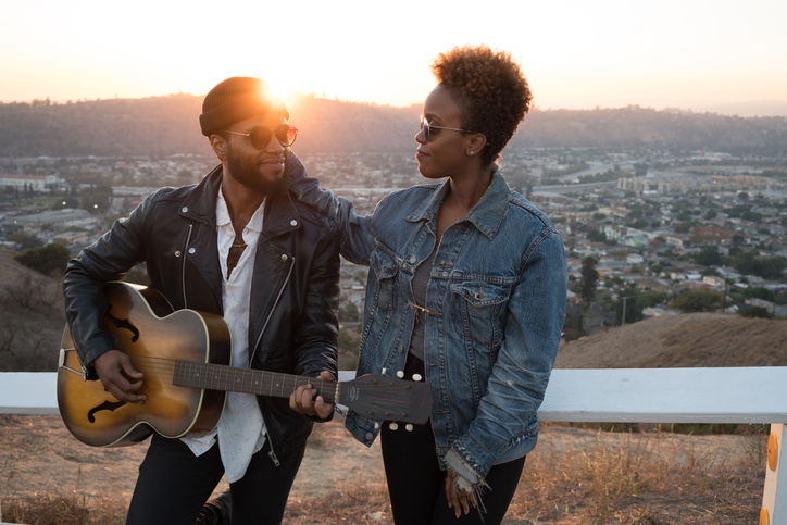 Young African American Couple Playing the Guitar in the Hills
