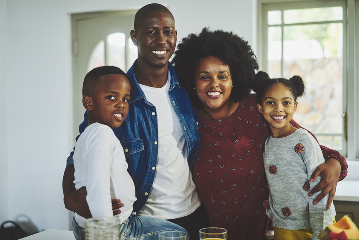 Loving family standing together in their living room at home