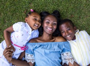 Young african-american family resting lying down on the grass