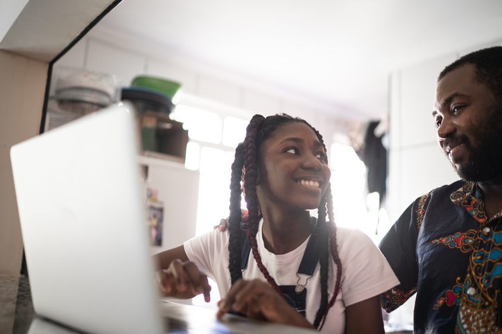 Dad helping his teenager doing homework at home
