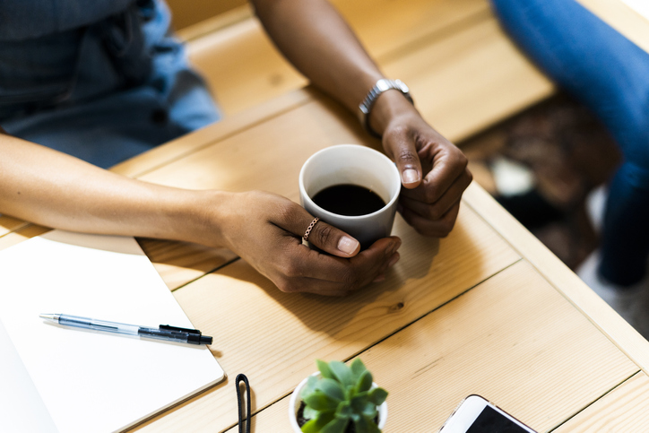 High angle view of woman holding black coffee at table in cafe