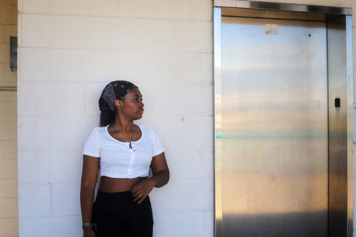 Full Length Of Woman Standing Against Wall