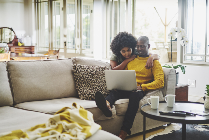 Content couple using a laptop in their living room