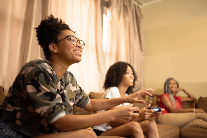 Two Teenage African American Sisters Playing Video Games at Home in Miami Florida