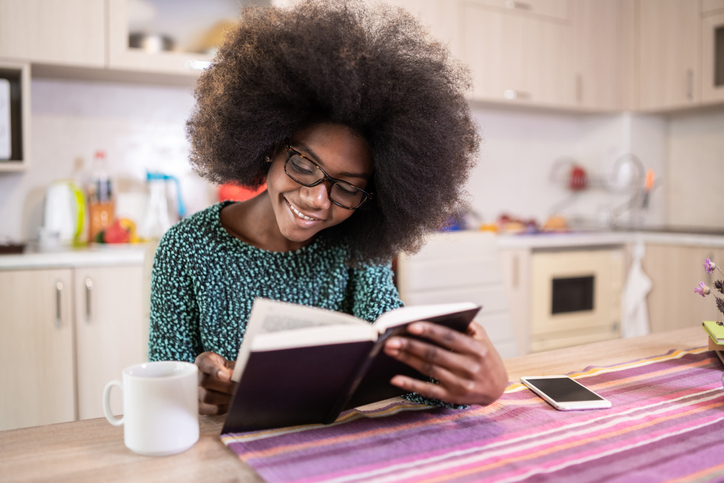 Young afro woman reading a book