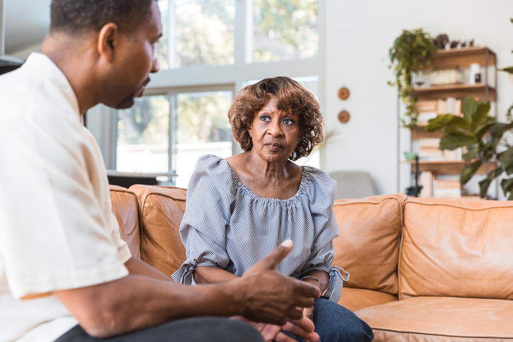 Mid adult male counselor visits lonely senior woman in home