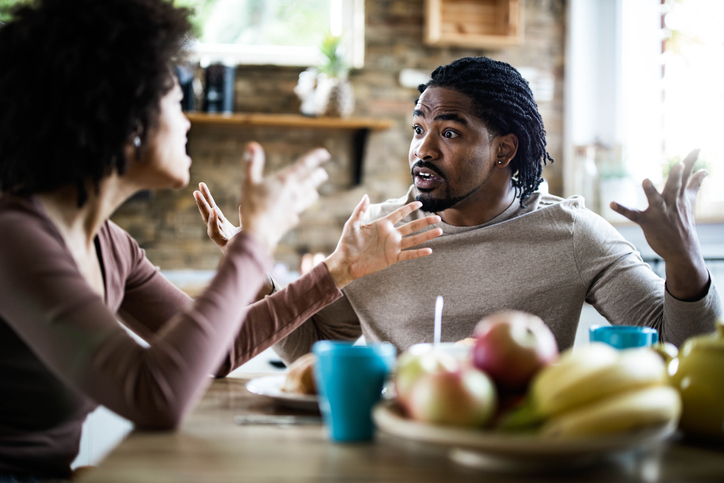 Angry African American man arguing with his girlfriend during breakfast in the morning.