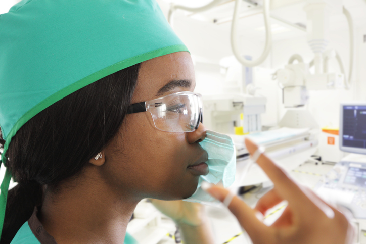 Medical professional putting on protective face mask