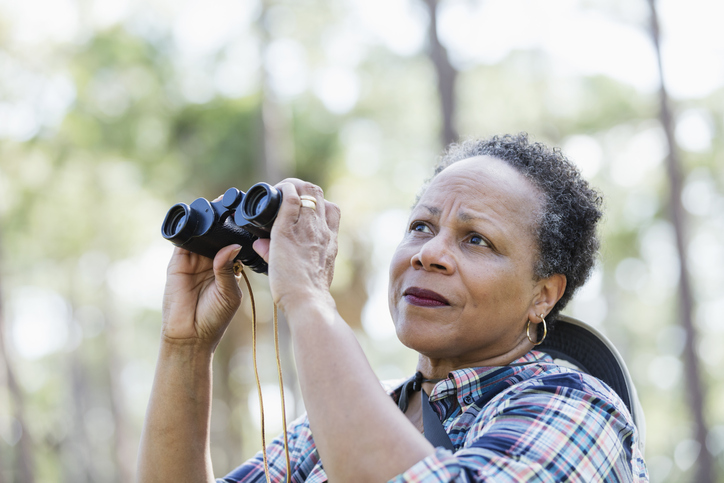 Senior African-American woman at a park with binoculars
