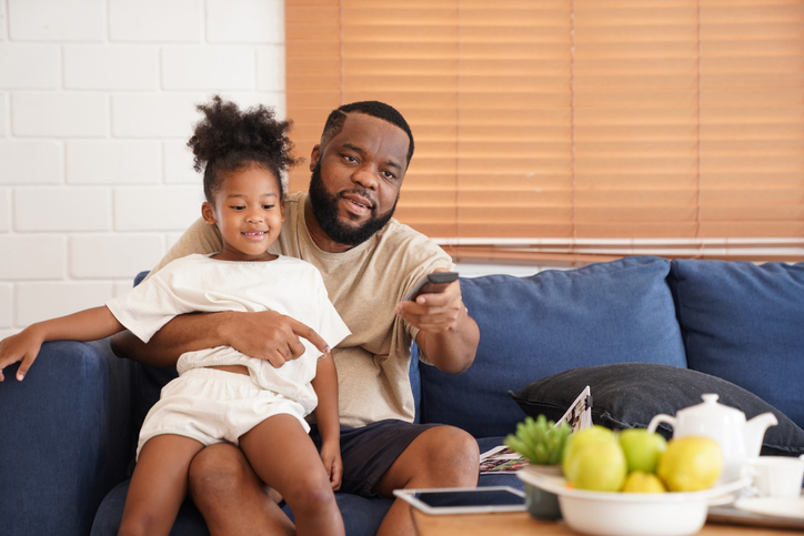 Father and child to happiness looking TV relaxing