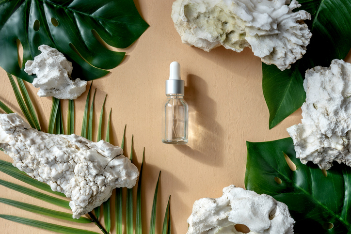 top view of face serum bottles, tree bark around