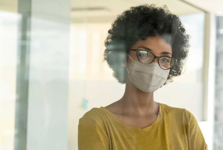 African American woman wearing a facemask while working at the office