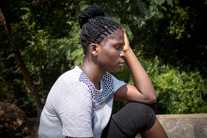 Young African American depressed sad woman in nature