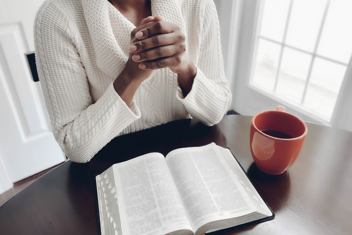 Woman Reads Bible at Kitchen Table
