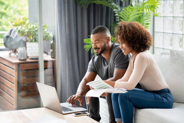 Loving African American couple paying bills online at home