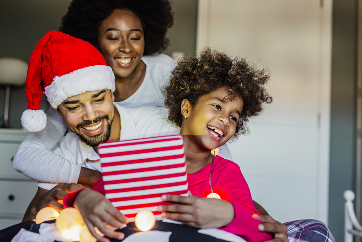 Happy African American family in bed during the Christmas holidays