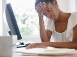 Frustrated Black businesswoman working at desk