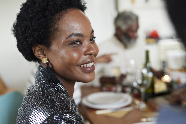 Close-up of smiling woman sitting at dining table