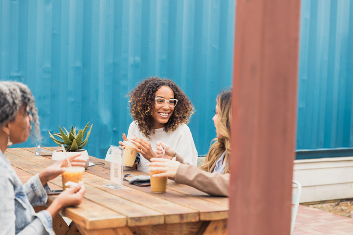 Three friends meet at outdoor restaurant during COVID-19