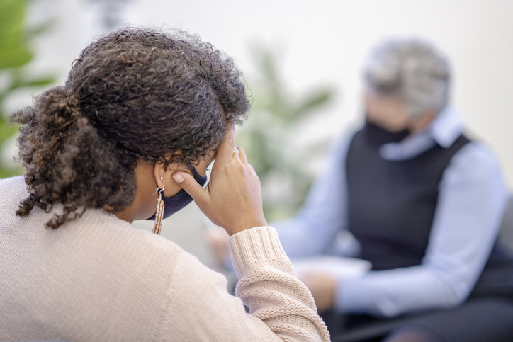 Female counselor wearing a mask during a session with a client