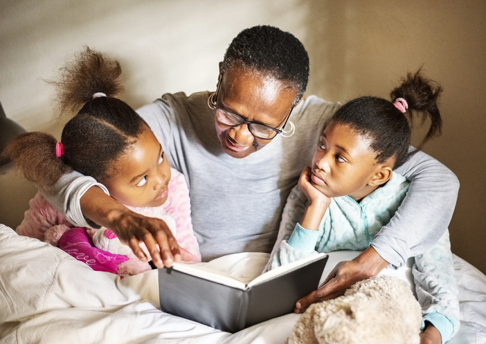 Granny reading to her granddaughters