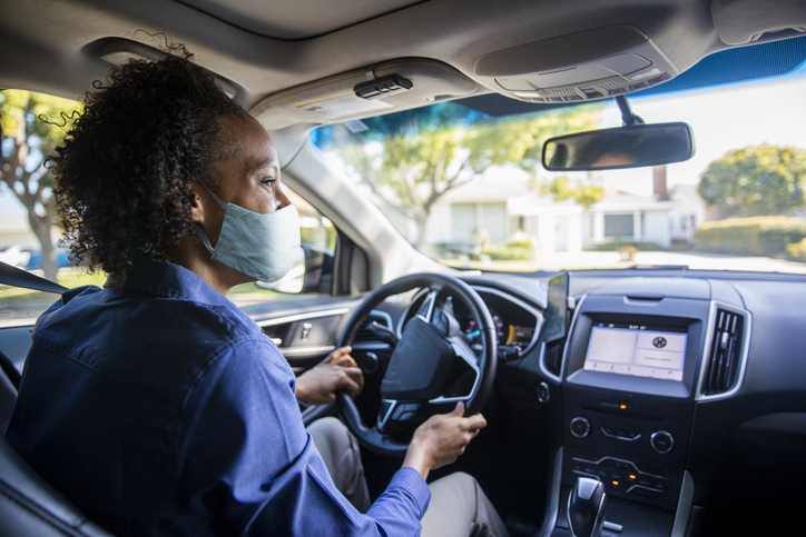 Young Black Woman Driving Car for Rideshare Wearing a Mask
