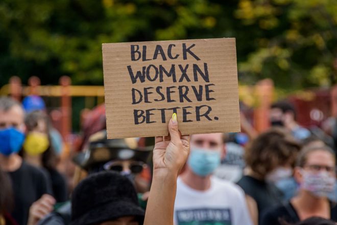 A participant holding a Black Women Deserve Better sign at...