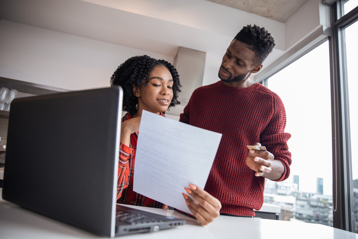 African American couple shopping online using their credit card