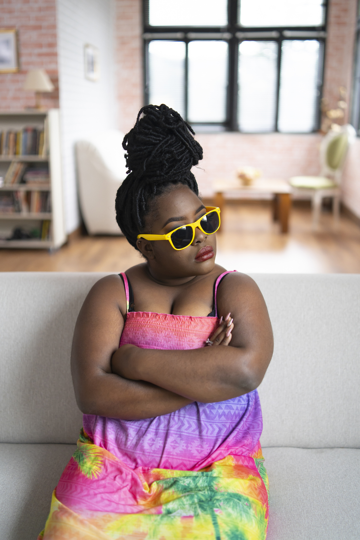 Offended african woman sitting arms crossed on sofa