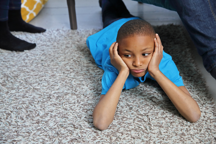 Boy lying on floor with hands on chin