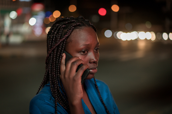 Girl calling taxi on city street in night