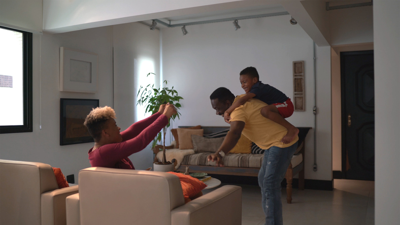 Family playing flying with boy at home